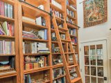 Custom library shelving with mahogany inlays and rolling library ladder